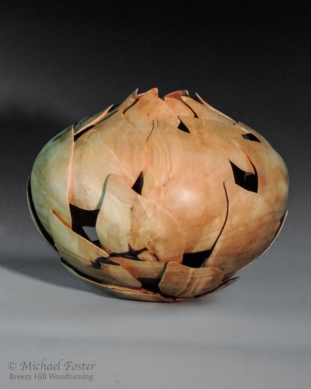 Fibonacci birch-   A piece turned from birch and carved with birch leaves arranged in 2 opposing spirals in a fibonacci pattern.----SOLD